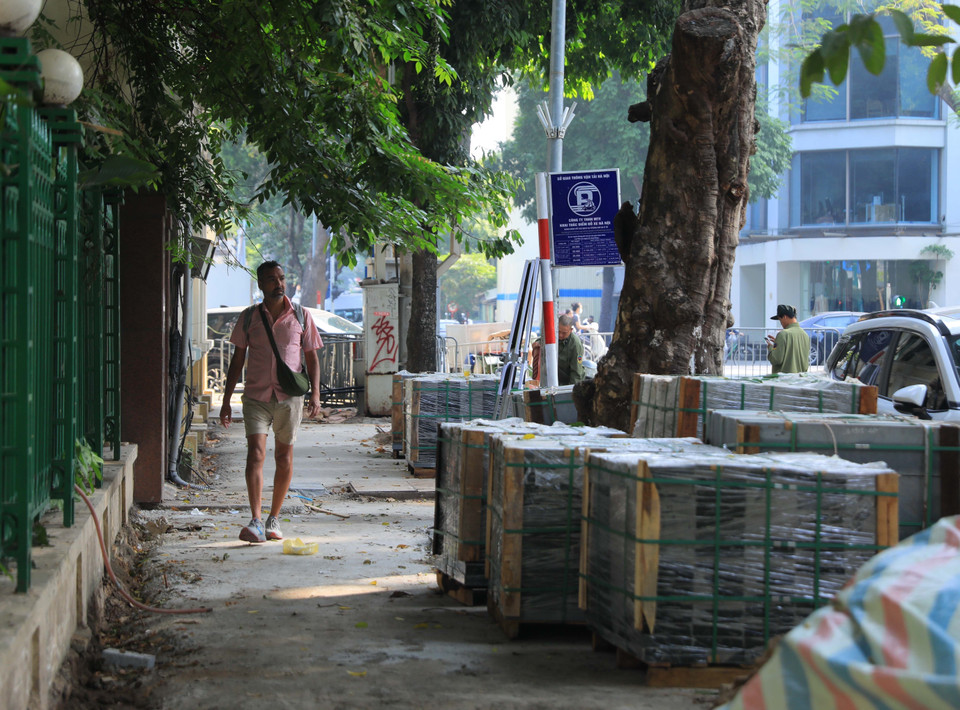 Một du khách đi giữa ngổn ngang vật liệu xây dựng vỉa hè phố Trần Nguyên Hãn, quận Hoàn Kiếm sáng 26/11. (Ảnh: Hoàng Hiếu/TTXVN)