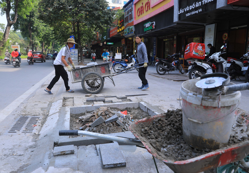 Công nhân gấp rút thi công vỉa hè phố Giảng Võ sáng 26/11. (Ảnh: Hoàng Hiếu/TTXVN)