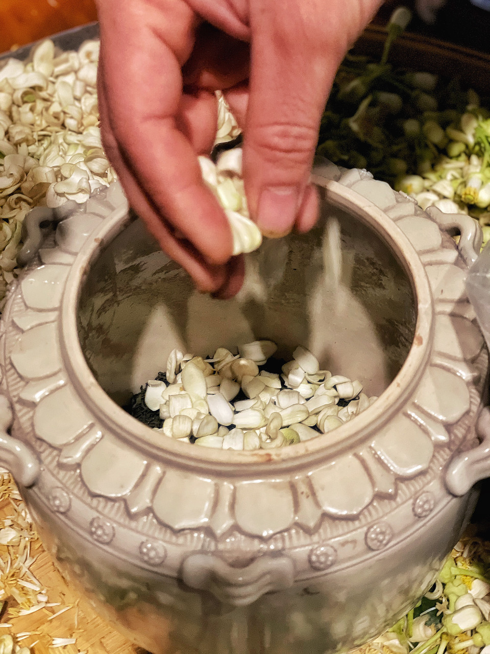 Mỗi một lớp trà là một lớp cánh hoa. Sau khi đủ thời gian ướp trà ta tiến hành sàng hoa, nhặt hoa khỏi trà và bắt đầu sấy trà. (Ảnh: Xuân Mai/Vietnam+)