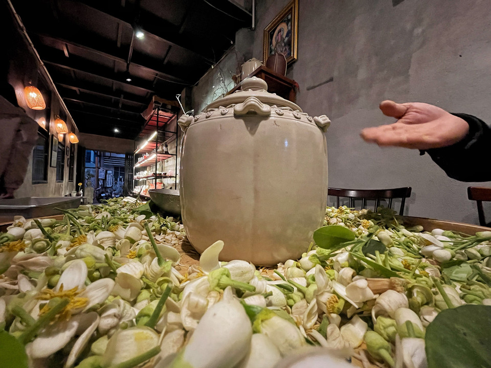 Bước cuối cùng là sấy khô trà hoa. Có thể sấy bằng chảo gang trên than hồng (không sấy lửa lớn khiến trà bị cháy, nhiệt độ tốt nhất chỉ khoảng 90-100 độ C), bằng đèn hoặc thời nay đã có máy sấy trà chuyên dụng. Trà khô rải ra để nguội trước khi cất vào hũ dùng dần. (Ảnh: Xuân Mai/Vietnam+)