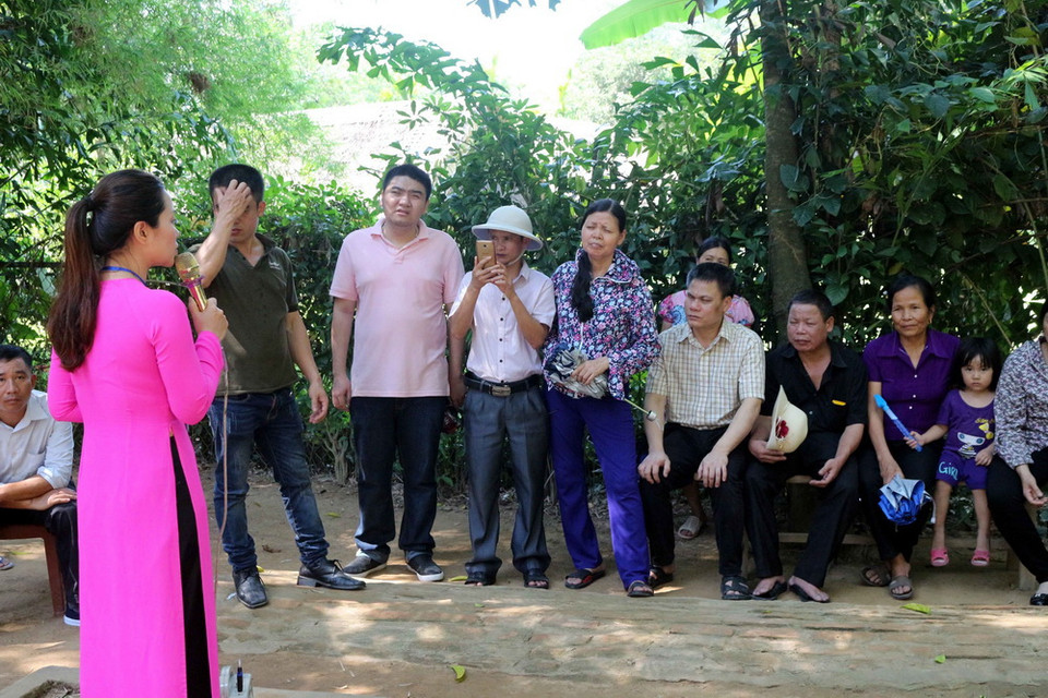 Hướng dẫn viên giới thiệu về Khu di tích Kim Liên và những câu chuyện về Người cho du khách từ phương xa về thăm quê Bác. (Ảnh: Bích Huệ/TTXVN)