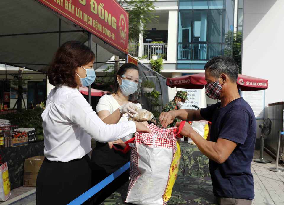 Trao quà cho các hộ nghèo, gia đình chính sách, người lao động mất việc làm, người có hoàn cảnh khó khăn. (Ảnh: Trần Việt/TTXVN)