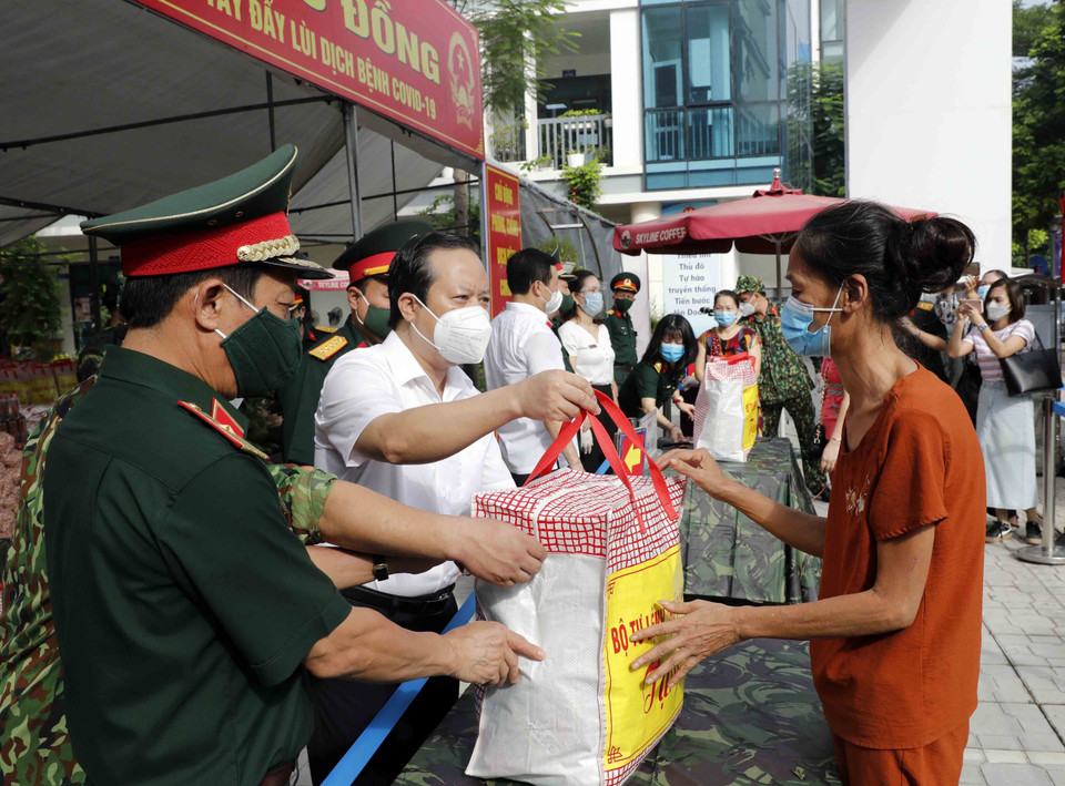Trao quà cho các hộ nghèo, gia đình chính sách, người lao động mất việc làm... (Ảnh: Trần Việt/TTXVN)