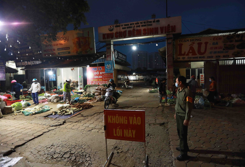 Ban quản lý chợ đầu mối Minh Khai triển khai các biện phát đảm bảo an toàn phòng, chống dịch, người đi ra và vào chợ theo một lối đi riêng. (Ảnh: Vũ Sinh/TTXVN)
