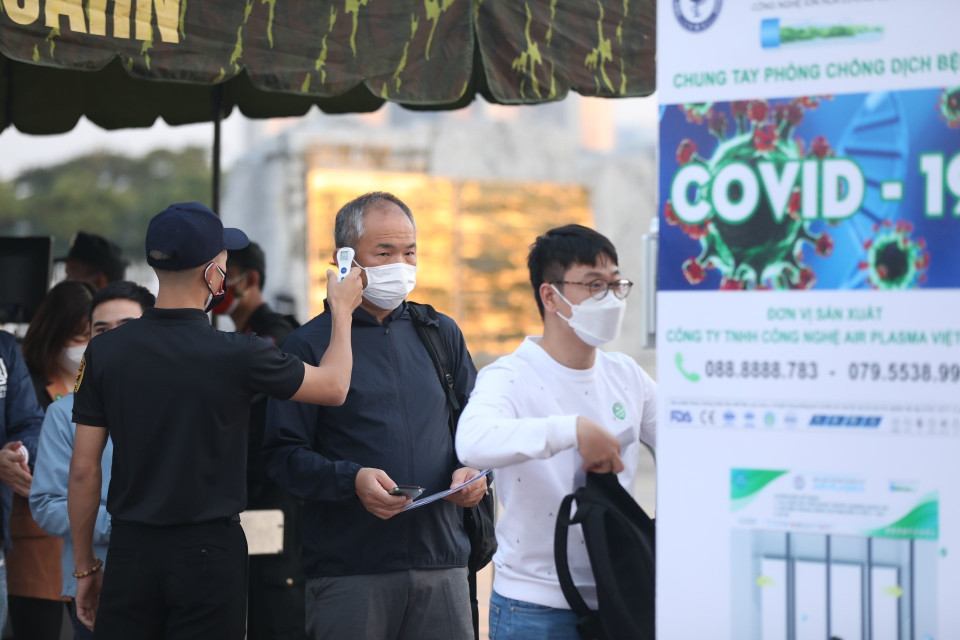 Khán giả đến sân được kiểm tra thân nhiệt đảm bảo quy định về phòng, chống dịch. (Ảnh: Minh Quyết/TTXVN)