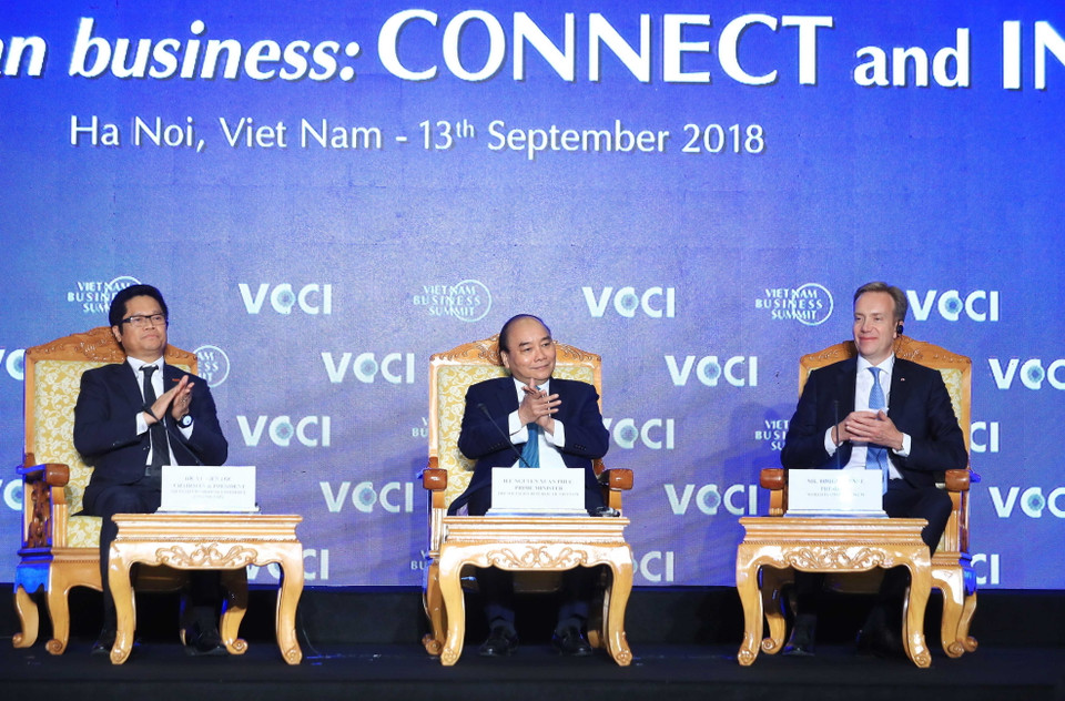 Thủ tướng Nguyễn Xuân Phúc, Chủ tịch Phòng Thương mại và Công nghiệp Việt Nam Vũ Tiến Lộc (bên trái) và Chủ tịch Diễn đàn Kinh tế thế giới (WEF) Borge Brende chủ trì hội nghị. (Ảnh: Thống Nhất/TTXVN)