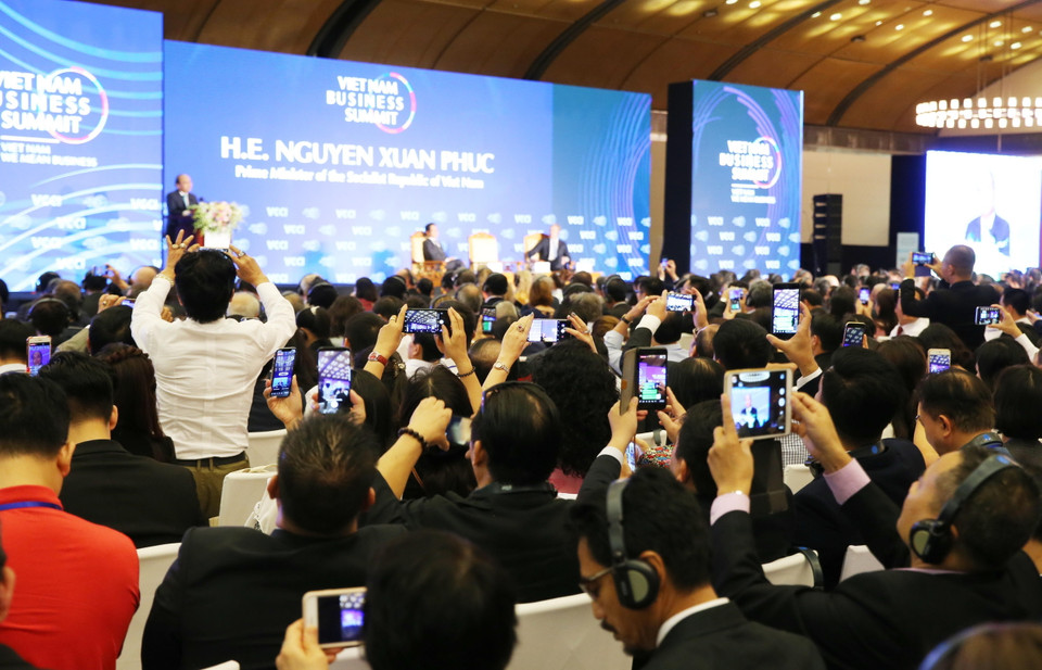 Các đại biểu sử dụng điện thoại thông minh để quay và phát trực tiếp (Live stream) diễn biến hội nghị. (Ảnh: Lâm Khánh/TTXVN)