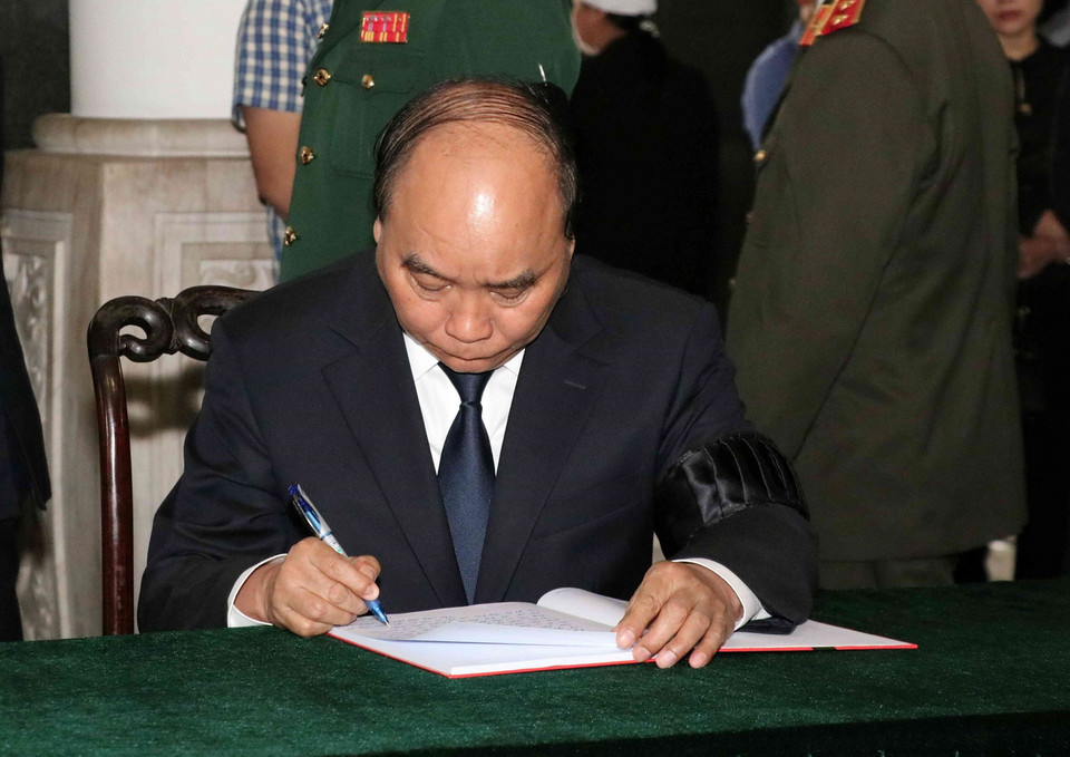 Thủ tướng Nguyễn Xuân Phúc viết sổ tang. (Ảnh: Văn Điệp/TTXVN)