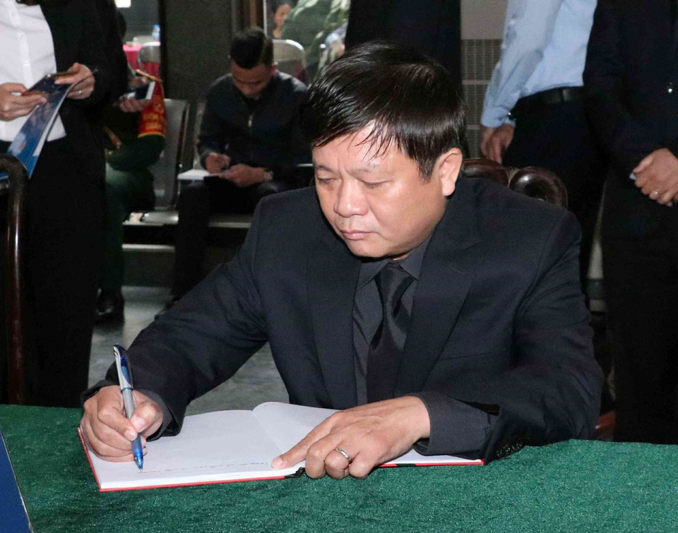 Phó Tổng Giám đốc TTXVN Đinh Đăng Quang viết sổ tang. (Ảnh: Văn Điệp/TTXVN)