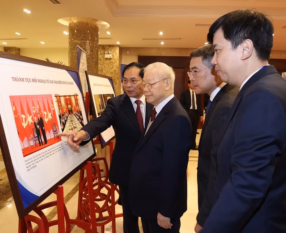 Tổng Bí thư Nguyễn Phú Trọng và các đại biểu tham quan trưng bày ảnh về Ngoại giao Việt Nam. (Ảnh: Trí Dũng/TTXVN)