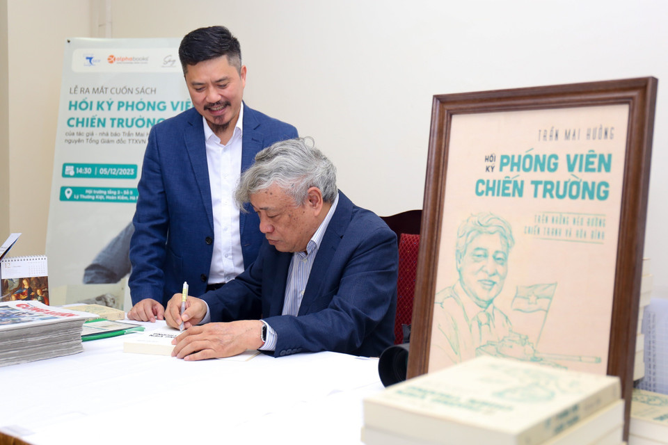 Tác giả Trần Mai Hưởng ký tặng sách. (Ảnh: Ngọc Anh/TTXVN)