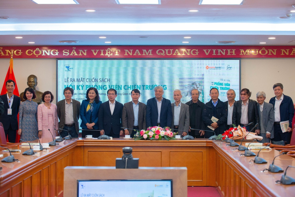 Đại diện Ban lãnh đạo Thông tấn xã Việt Nam cùng tác giả Trần Mai Hưởng và các đại biểu chụp ảnh lưu niệm. (Ảnh: Thảo Quyên/TTXVN phát)