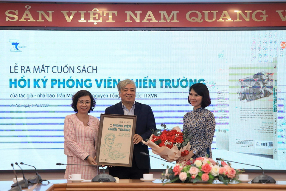 Giám đốc Nhà Xuất bản Thông tấn Phùng Thị Mỹ và đại diện Công ty Alpha Books tặng quà cho tác giả Trần Mai Hưởng. (Ảnh: Ngọc Anh/TTXVN phát)