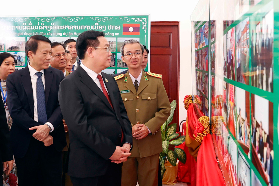 Chủ tịch Quốc hội Vương Đình Huệ xem trưng bày ảnh tại Học viện Chính trị Công an Lào. (Ảnh: Doãn Tấn/TTXVN)