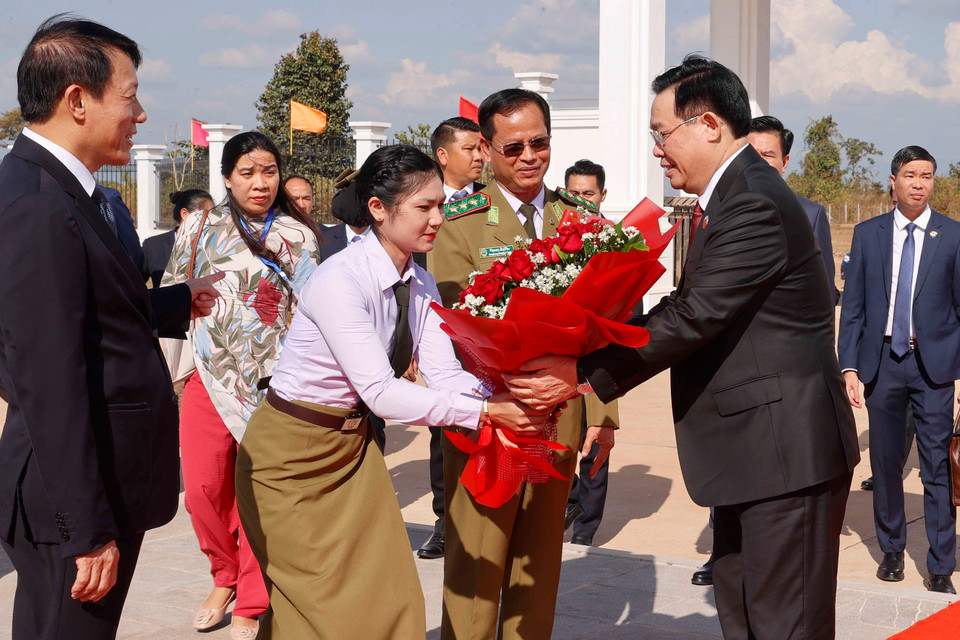 Lãnh đạo Học viện Chính trị Công an Lào đón, tặng hoa Chủ tịch Quốc hội Vương Đình Huệ. (Ảnh: Doãn Tấn/TTXVN)