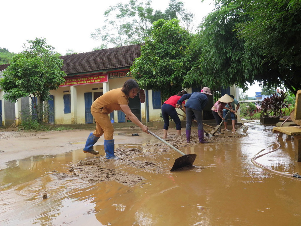 Giáo viên, phụ huynh trường tiểu học Tân Lang, huyện Phù Yên dọn dẹp bùn đất trên sân trường. (Ảnh: Hữu Quyết/TTXVN)