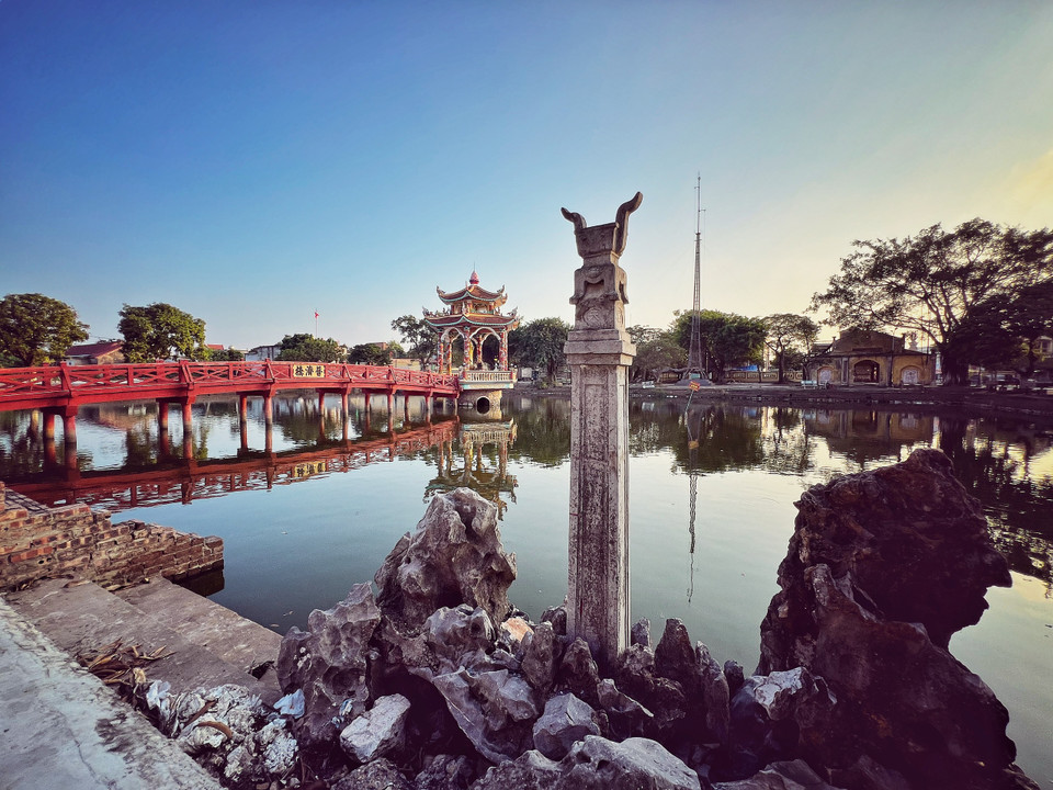 Trước chùa là hồ nước trong xanh, rộng lớn như tấm gương in bóng tam quan, “Thiên thạch đài trụ”, cùng các cây cổ thụ xung quanh càng tôn vẻ đẹp của tổng thể công trình. (Ảnh: Mai Mai/Vietnam+)