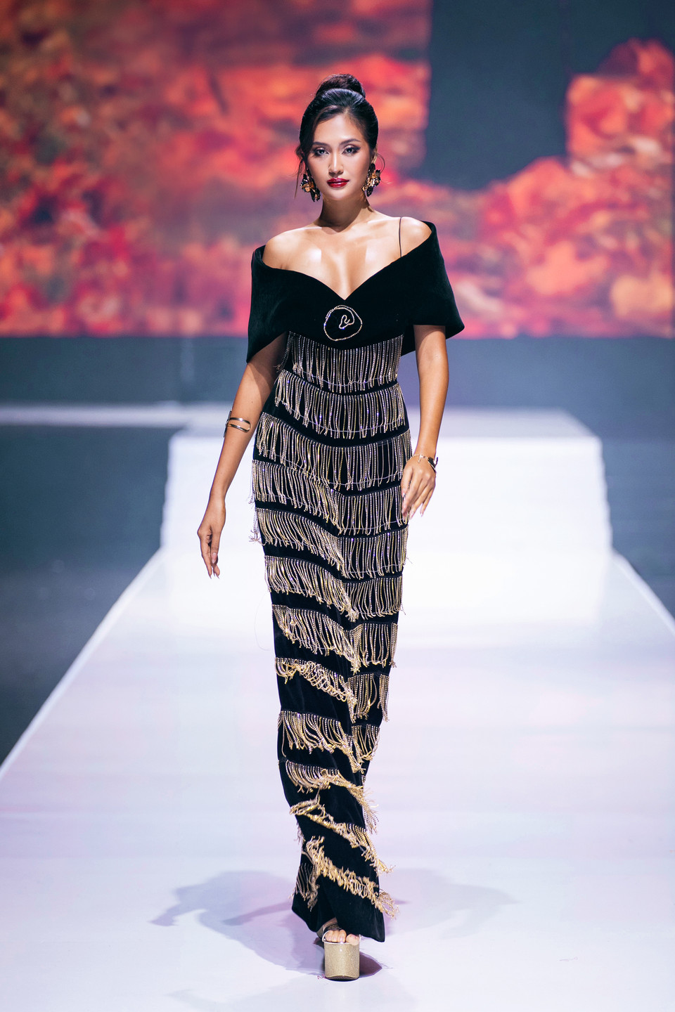 Mở màn cho chương mùa Thu lá vàng, Miss Cosmo 2024 Tata Juliastrid tỏa sáng trong thiết kế đầm nhung đen huyền bí, điểm xuyết bởi những đường tua rua vàng gold lấp lánh. (Ảnh: PV/Vietnam+)