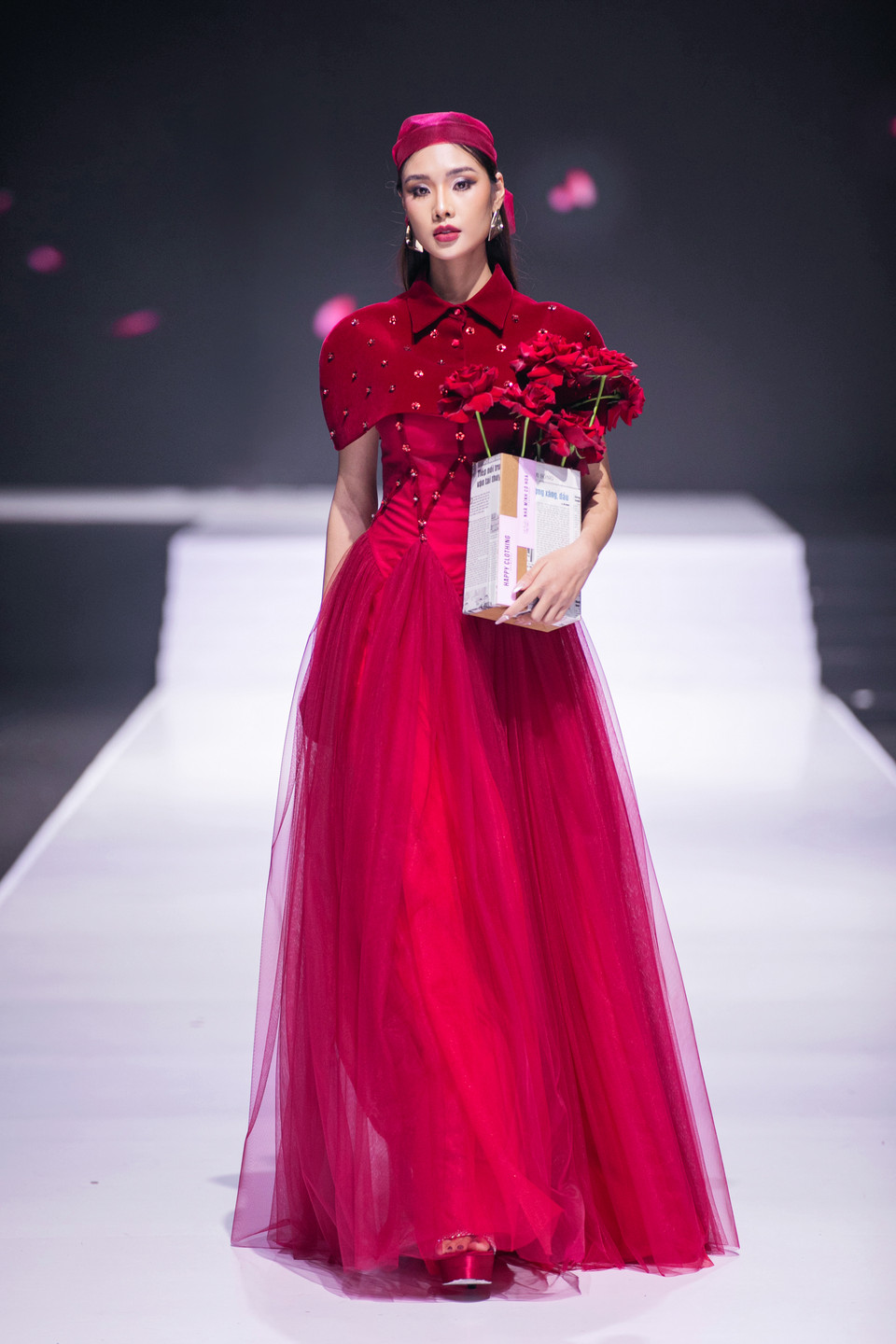 Các mẫu váy kết hợp cùng áo choàng lần lượt được các người mẫu trình diễn trên sân khấu. (Ảnh: PV/Vietnam+)