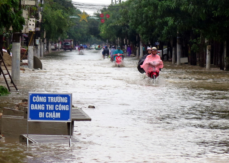 Đoạn đường Nguyễn Biểu, thành phố Hà Tĩnh nước ngập sâu, gây khó khăn cho người tham gia giao thông. (Ảnh: Công Tường/TTXVN) 