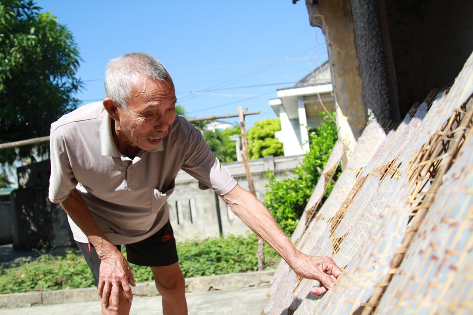 Vào những ngày Hè nắng như đổ lửa, người dân vẫn miệt mài bên những phên bánh bỏng nắng. (Ảnh: Xuân Mai/Vietnam+) ​