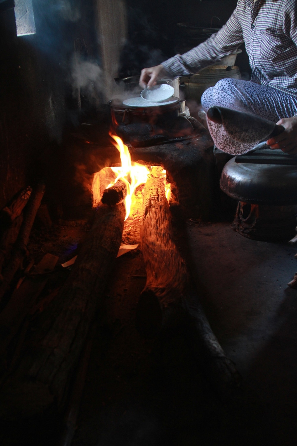 Dù ngoài trời hơn 40 độ C và phải ngồi tráng bánh bên bếp lò 50-60 độ C nhưng người dân vẫn quyết tâm gắn bó với nghề. (Ảnh: Xuân Mai/Vietnam+) ​