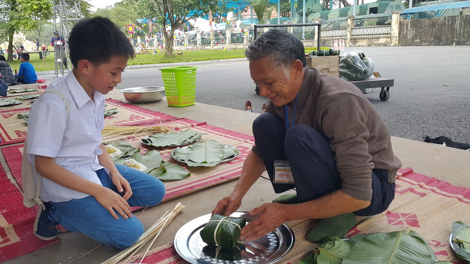 Hướng dẫn gói bánh chưng tại chương trình Tết Việt. (Ảnh: Đinh Thuận/TTXVN)