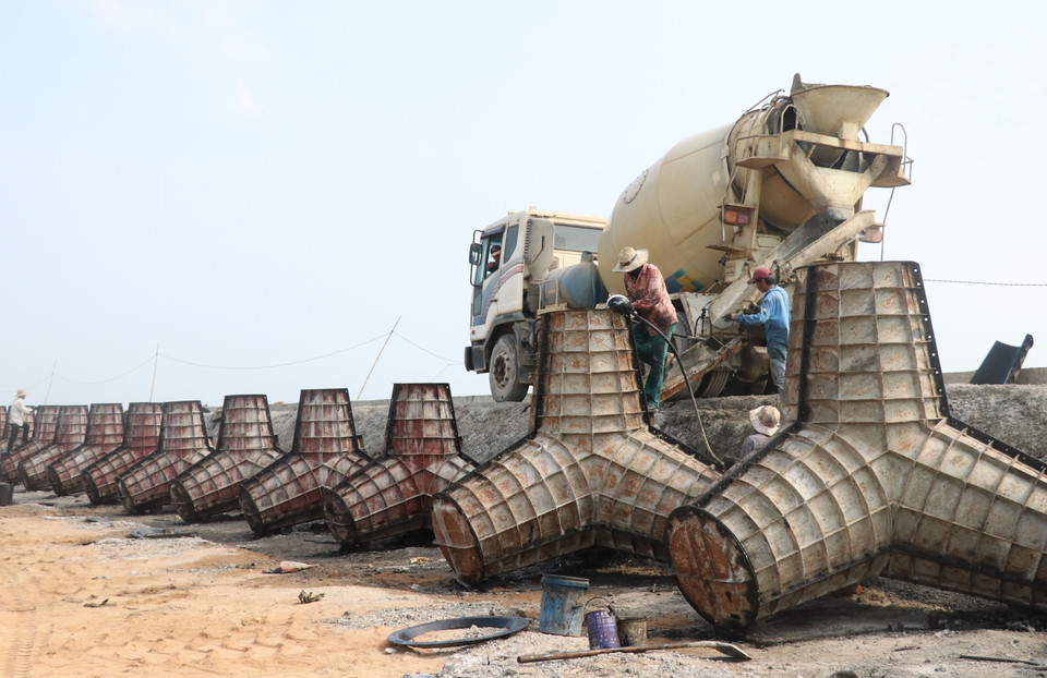 Công nhân thi công các cấu kiện bêtông chắn sóng phục vụ thi công kè Đà Diễn phía Nam. (Ảnh: Phạm Cường/TTXVN)