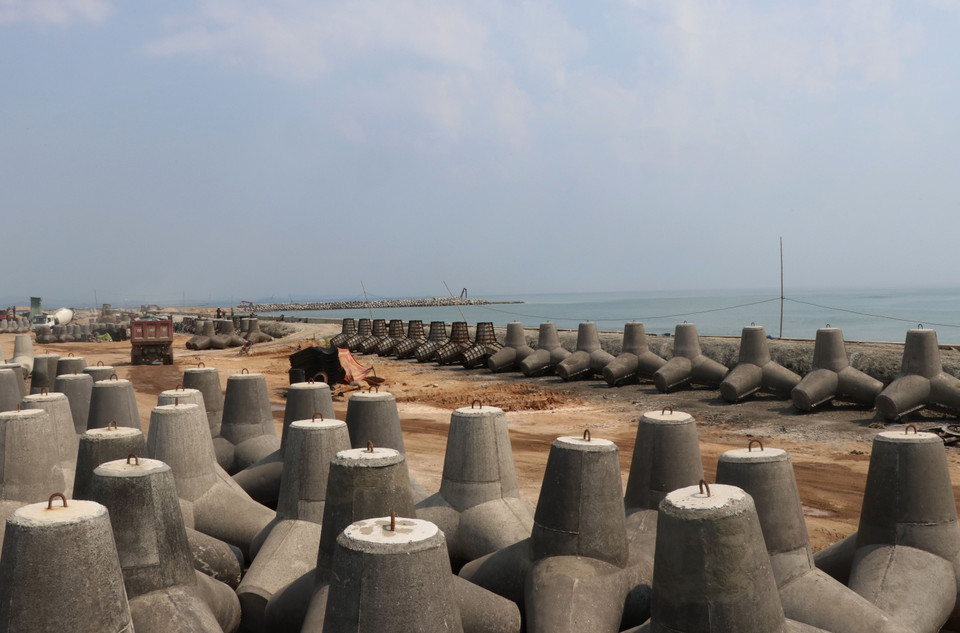 Kè biển Đà Diễn phía Nam dài 800m có kết cấu đá học kết hợp trụ bêtông chắn sóng đang được gấp rút hoàn thành. (Ảnh: Phạm Cường/TTXVN)