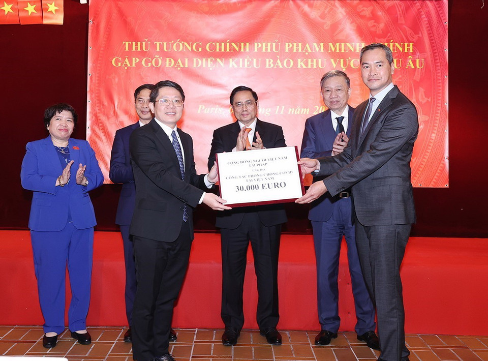 Thủ tướng Phạm Minh Chính chứng kiến trao biểu trưng ủng hộ phòng, chống dịch. (Ảnh: Dương Giang/TTXVN)