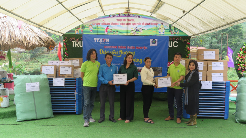 Trao tặng các phần quà đến cô và trò Trường Mầm non Nậm Lúc. (Ảnh: Hương Thu/TTXVN)