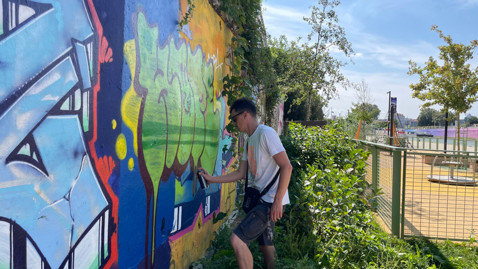 Họa sỹ Meuh, một chuyên gia vẽ tranh graffiti, sáng tạo tác phẩm của mình trên đường phố. (Ảnh: Thu Hà/TTXVN)