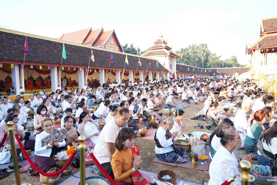 Người dân Lào tham gia đang thực hiện nghi lễ Xaybath trong khuôn viên của chùa Thatluang. (Ảnh: Đỗ Bá Thành/TTXVN)