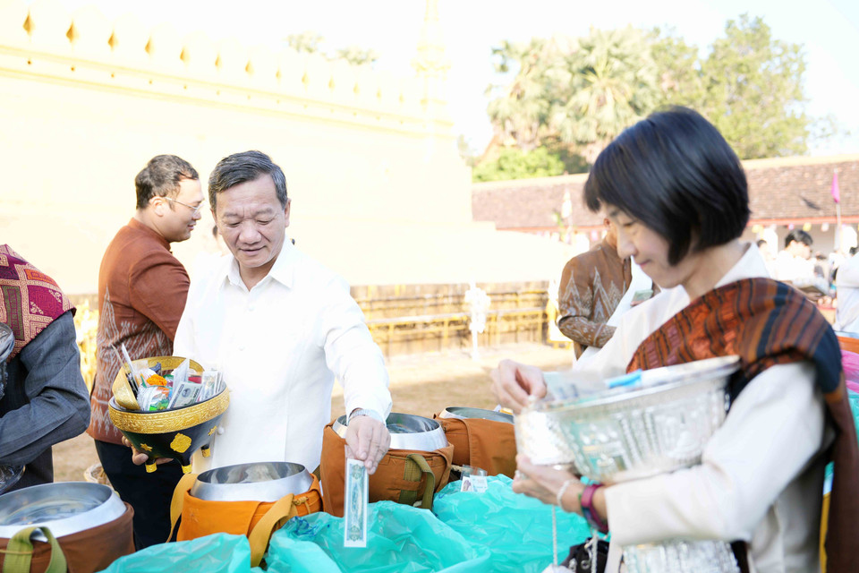 Các đại biểu quốc tế đang thực hiện nghi lễ Xaybath trong khuôn viên của chùa Thatluang. (Ảnh: Đỗ Bá Thành/TTXVN)