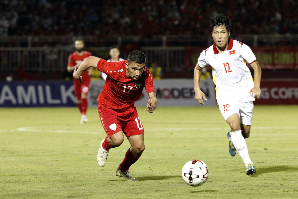 Pha tranh bóng giữa các tuyển thủ Việt Nam (áo trắng) với các cầu thủ Afghanistan. (Ảnh: Thanh Vũ/TTXVN)