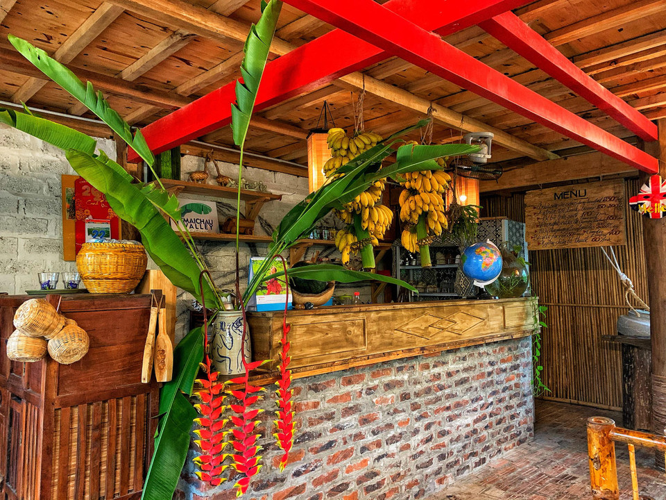 Quầy bar đơn giản mà tinh tế. Hai buồng chuối treo lên dành cho khách, chín đến đâu khách tự hái đến đó. (Ảnh: Xuân Mai/Vietnam+)
