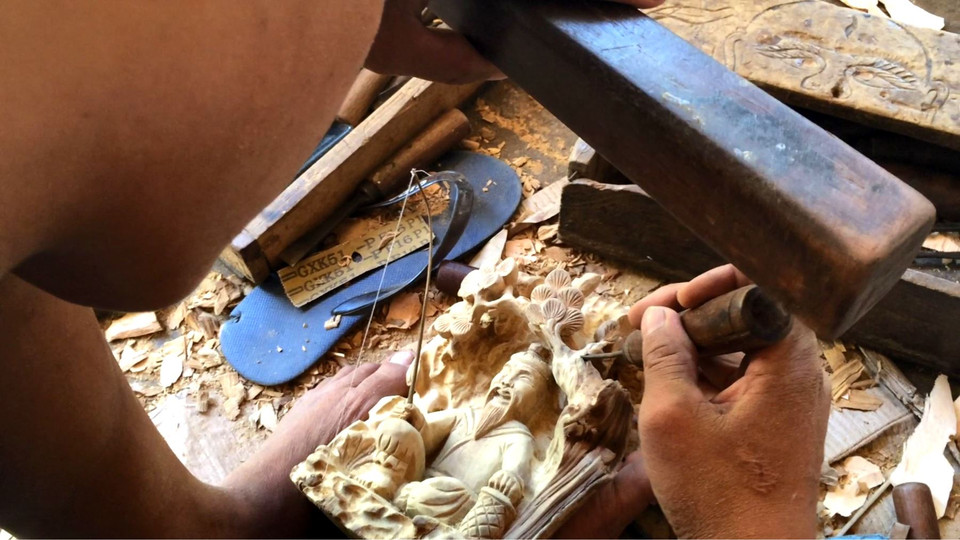 Hình ảnh nghệ nhân Kim Bồng đầy khéo léo, cần mẫn đục, khoan để tạo nên những sản phẩm tinh xảo mang tính nghệ thuật và giá trị văn hóa cao. (Ảnh: Xuân Mai/Vietnam+)