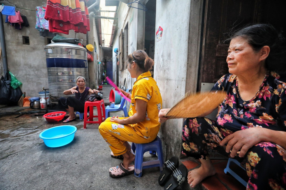 Phòng trọ chật hẹp, nóng bức, thiếu ánh sáng nên mọi người phải tận dụng khu vực hành lang rộng hơn 1m đất làm nơi sinh hoạt. Mọi hoạt động nấu nướng, giặt đồ, phơi đồ đều diễn ra trên khu vực này. (Ảnh: Thành Đạt/TTXVN)