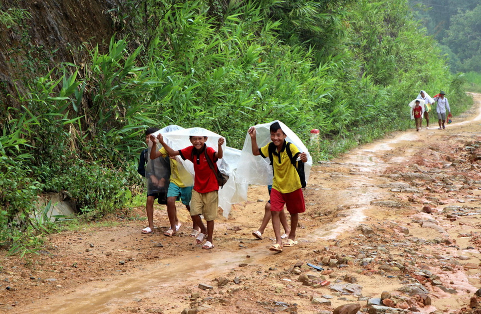 Học sinh đội mưa, vượt đường trơn để đến trường dự Lễ khai giảng năm học mới. (Ảnh: Việt Hoàng/TTXVN)