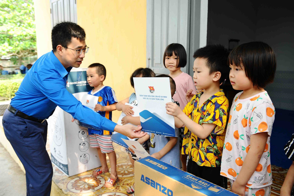 Quyền Bí thư Đoàn Khối các cơ quan Trung ương Bùi Hoàng Tùng trao học bổng cho học sinh tại huyện đảo. (Ảnh: Minh Đức/TTXVN)