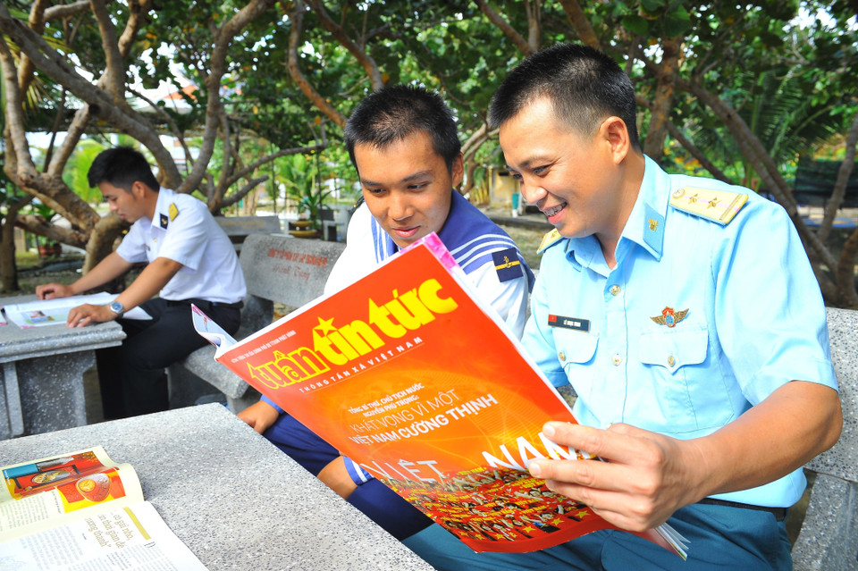 Các chiến sỹ đọc báo trên đảo Phan Vinh. (Ảnh: Minh Đức/TTXVN)