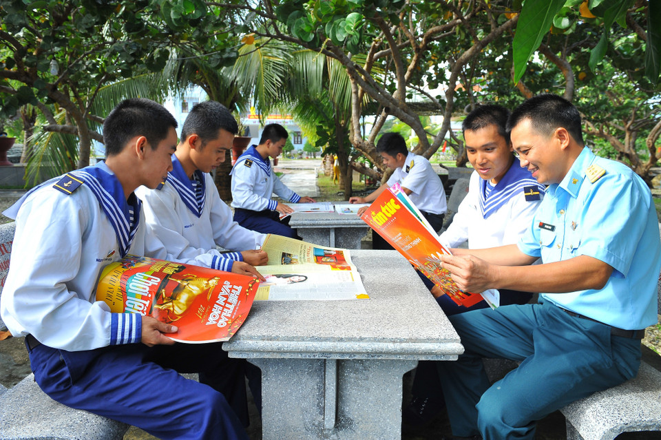 Các chiến sỹ đọc báo trên đảo Phan Vinh. (Ảnh: Minh Đức/TTXVN)