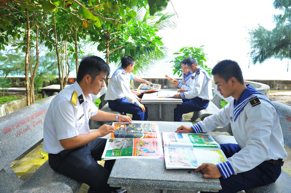 Các chiến sỹ đọc báo trên đảo Phan Vinh. (Ảnh: Minh Đức/TTXVN)