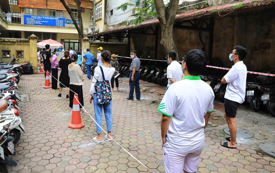 Người dân quận Hoàn Kiếm đến làm xét nghiệm COVID-19 xếp hàng đảm bảo giãn cách phòng chống dịch theo quy định (ảnh chụp chiều 15/5). (Ảnh: Thành Đạt/TTXVN)