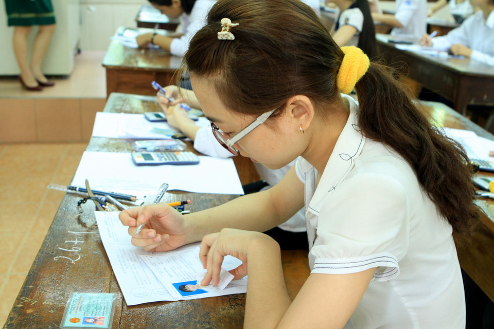 Kiểm tra thông tin lần cuối trong khi đợi đề thi. (Ảnh: Xuân Mai/Vietnam+)