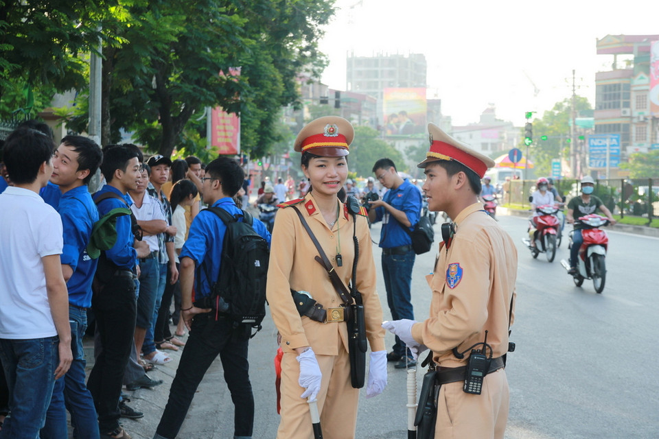Công an và sinh viên tình nguyện cùng phối hợp trước cổng Học viện Báo chí và Tuyên truyền. (Ảnh:Minh Sơn/Vietnam+)