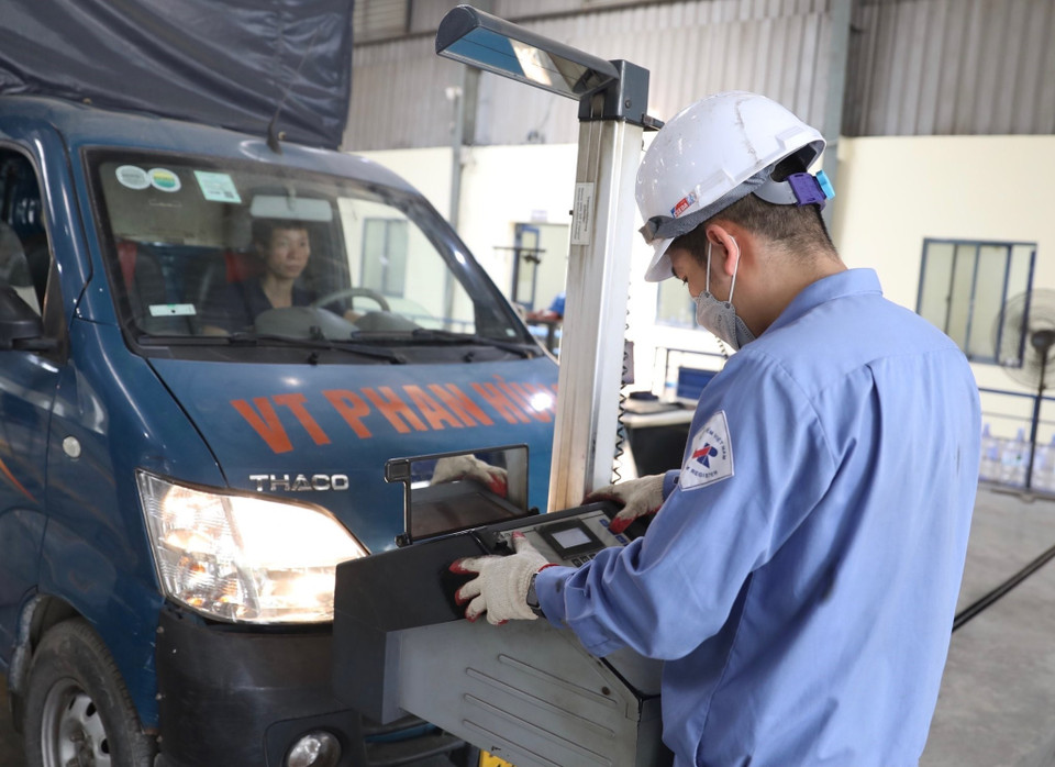 Nhân viên đăng kiểm Trung tâm đăng kiểm xe cơ giới 2906V kiểm tra hệ thống chiếu sáng của xe. (Ảnh: Hoàng Hiếu/TTXVN)