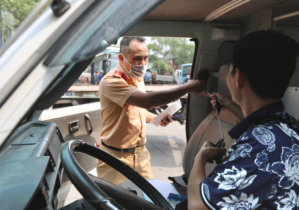 Đại úy công an Tô Anh Dũng (PC08 Nghệ An) kiểm tra hệ thống đai an toàn của xe đến đăng kiểm tại Trung tâm đăng kiểm xe cơ giới 2906V ở Tam Hiệp, Thanh Trì, Hà Nội. (Ảnh: Hoàng Hiếu/TTXVN)