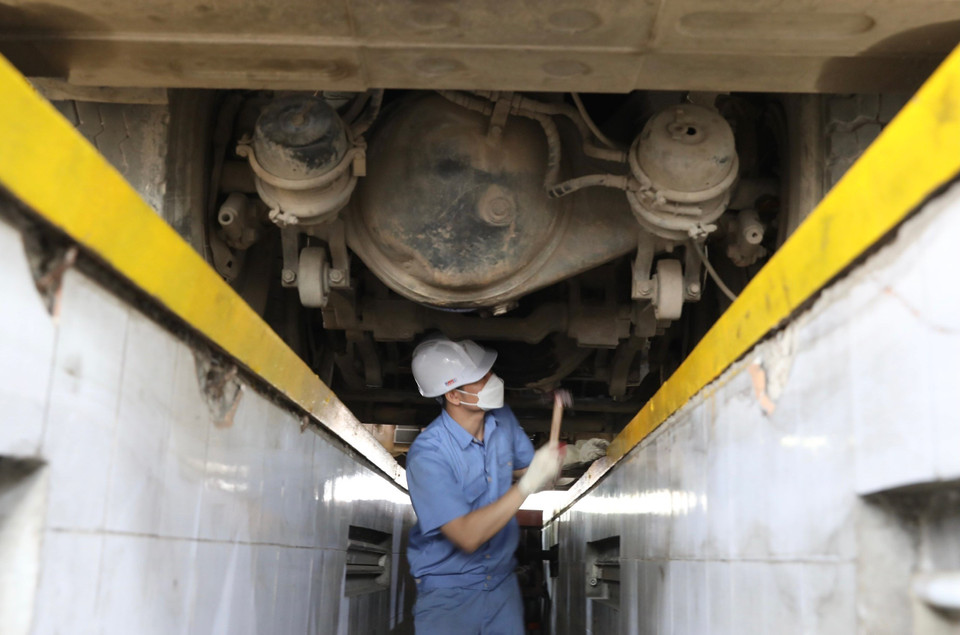 Nhân viên đăng kiểm Trung tâm đăng kiểm xe cơ giới 2906V ở Tam Hiệp, Thanh Trì, Hà Nội kiểm tra gầm xe. (Ảnh: Hoàng Hiếu/TTXVN)