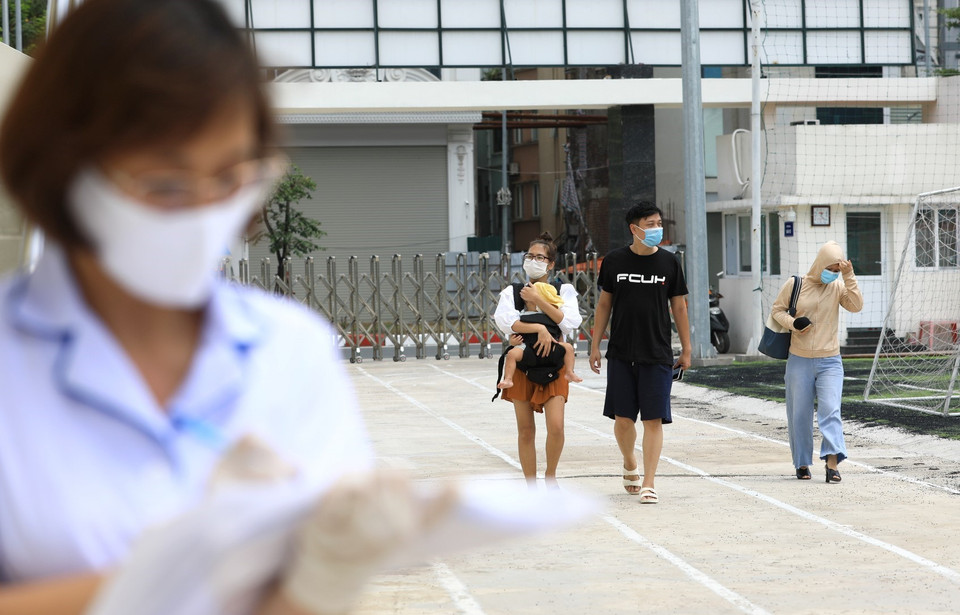  Từ sáng sớm, nhiều gia đình đã đến Trung tâm Văn hóa Thông tin và Thể Thao quận Đống Đa (237 Đặng Tiến Đông) - nơi xét nghiệm cho người dân quận Đống Đa trở về từ Đà Nẵng để được xét nghiệm RT-PCR. (Ảnh: Thành Đạt/TTXVN)